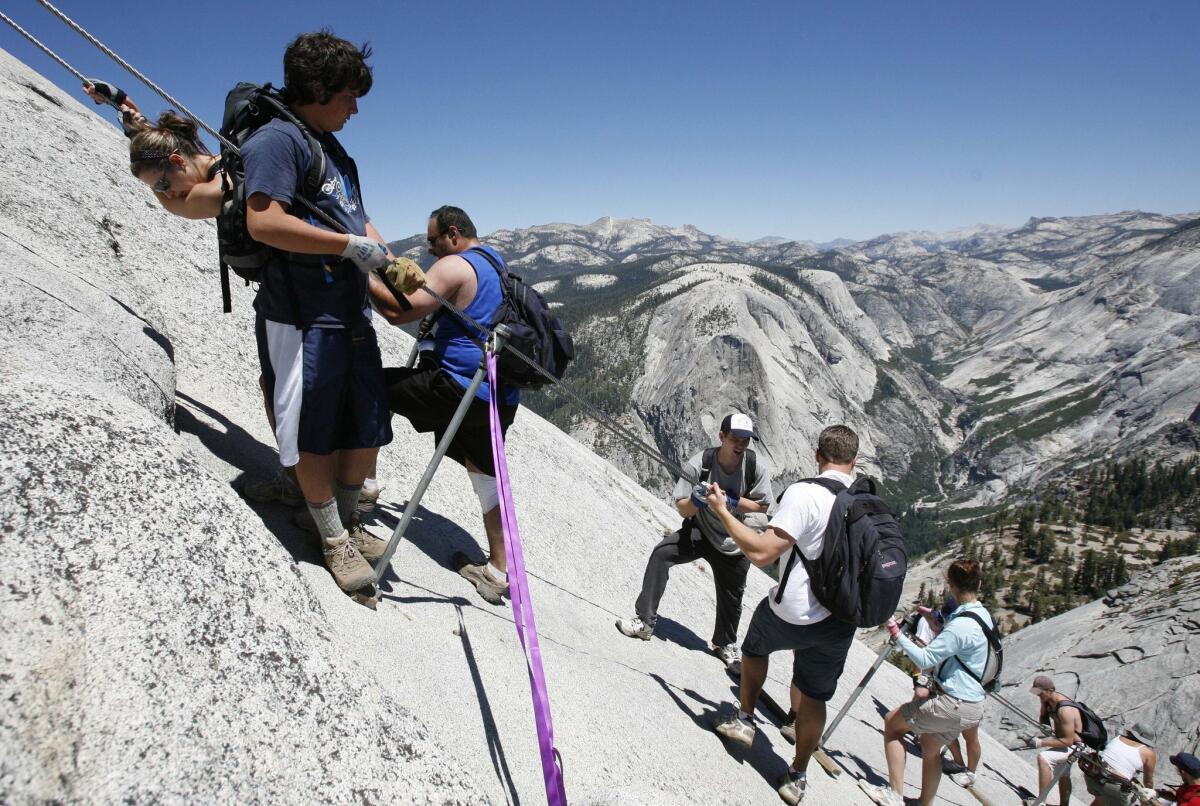 Climbers on the cable section of Half Dome negotiate the steep granite pitch in Yosemite National Park, Calif.