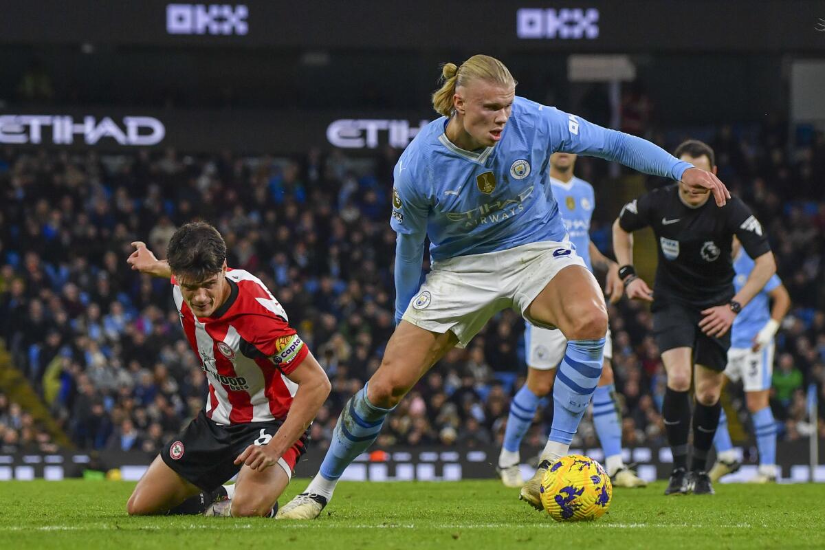 Erling Haaland (derecha) del Manchester City pugna por el balón con Christian Norgaard 