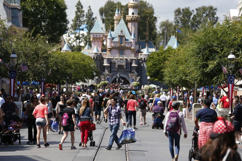 Patrons walk along Main Street in Disneyland.