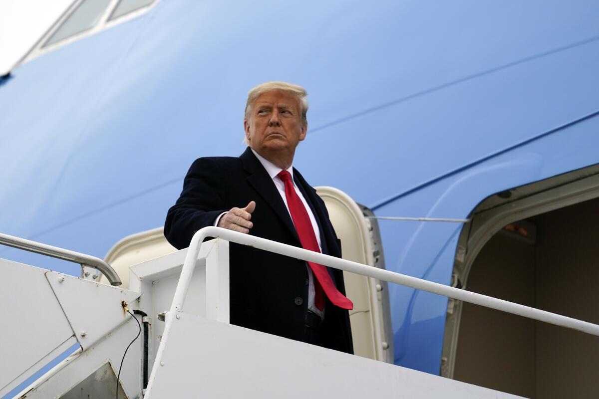 Donald Trump outside the entrance to an airplane.