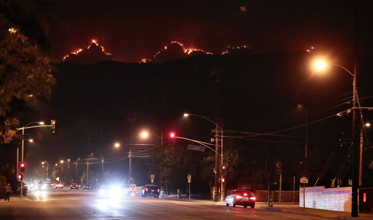 The Bobcat Fire smolders in the mountains above Monrovia Thursday.