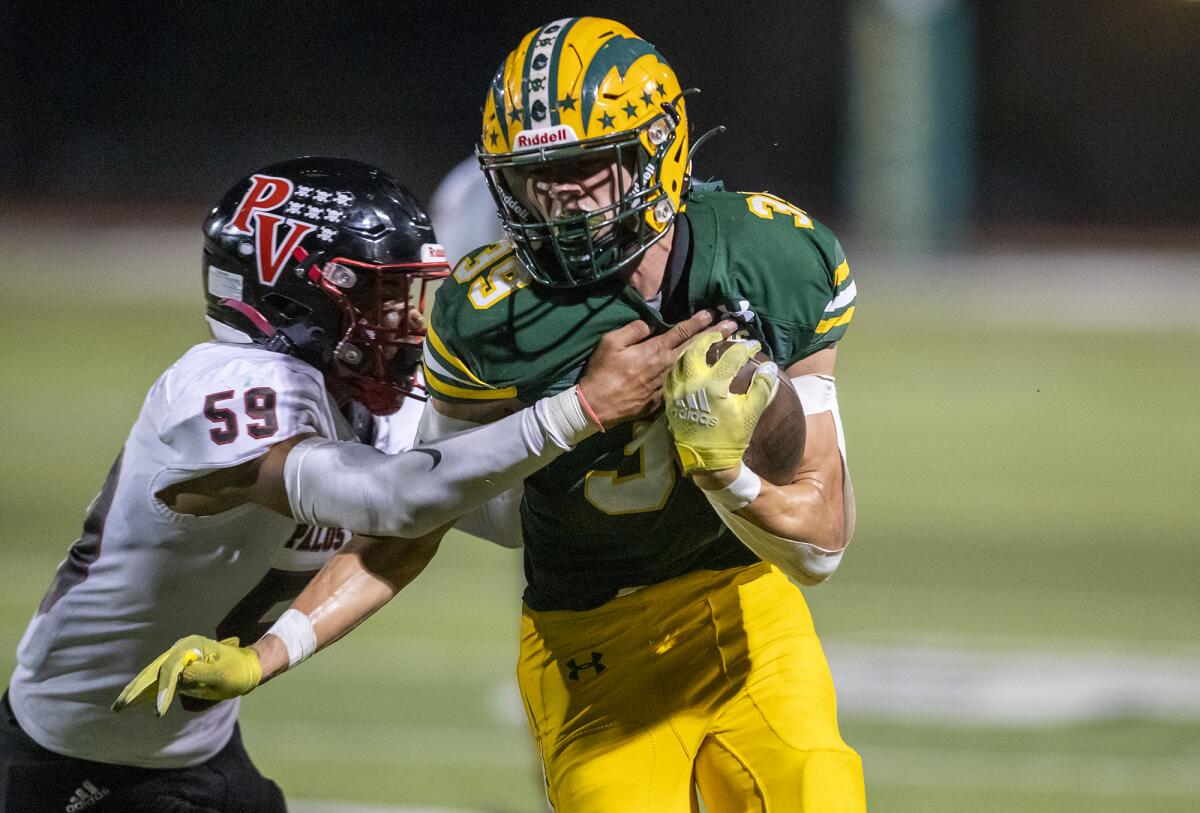 Edison's Carter Hogue is wrapped up by Palos Verdes' Michael Clemons during a game at Westminster High on Thursday.