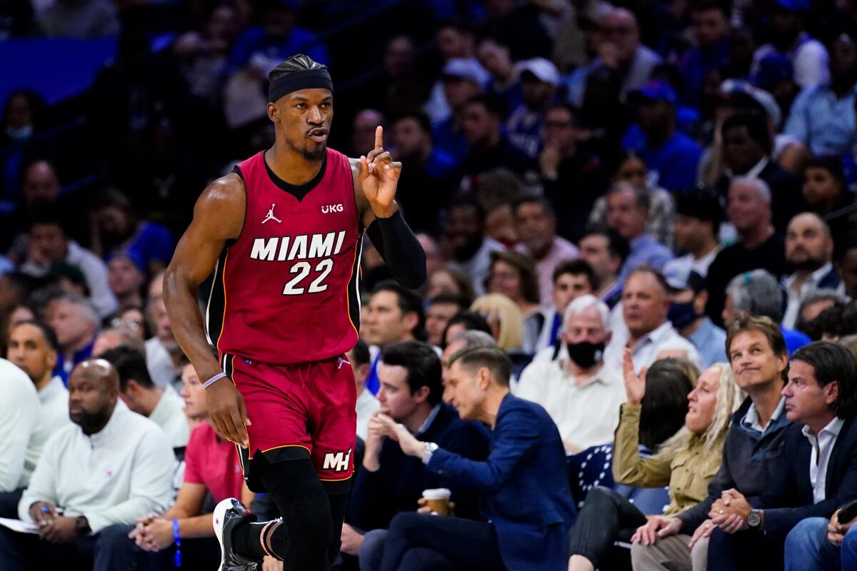 Miami Heat's Jimmy Butler gestures as he runs down the court.