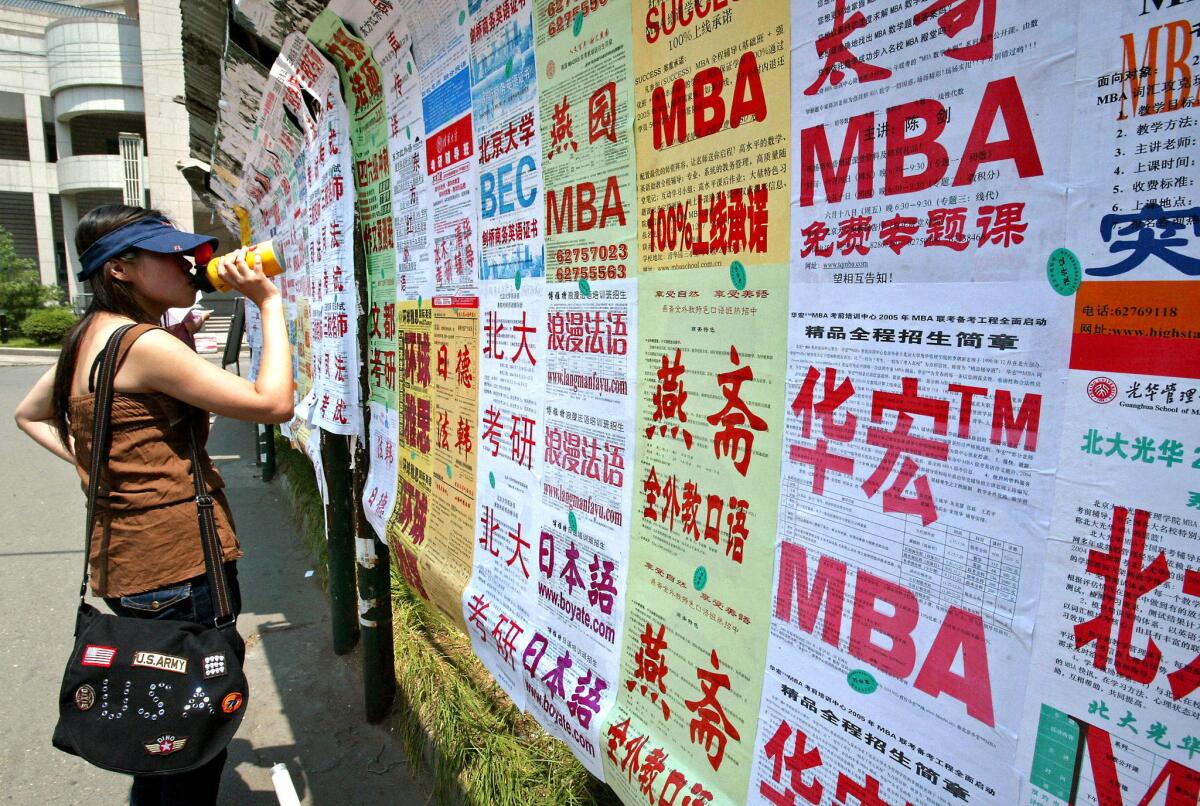 A student at Peking University stops to read ads promoting educational and career opportunities. The university is considered the Harvard of China.