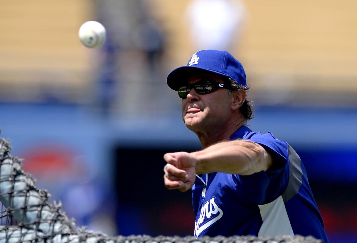 Dodgers Manager Don Mattingly pitches during batting practice before a baseball game against the St. Louis Cardinals.
