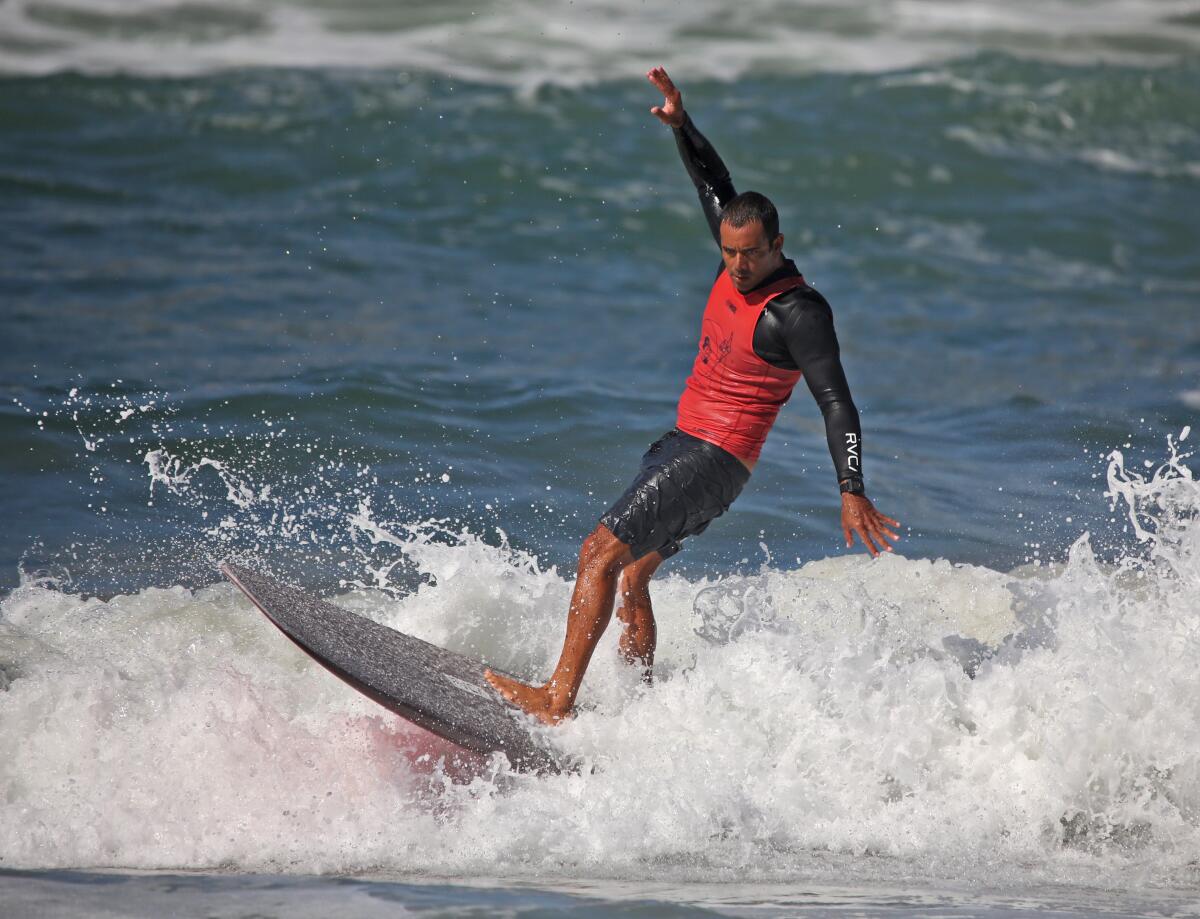 Kai Sallas of Hawaii catches a wave during the U.S. Open of Surfing, in Huntington Beach on Friday.