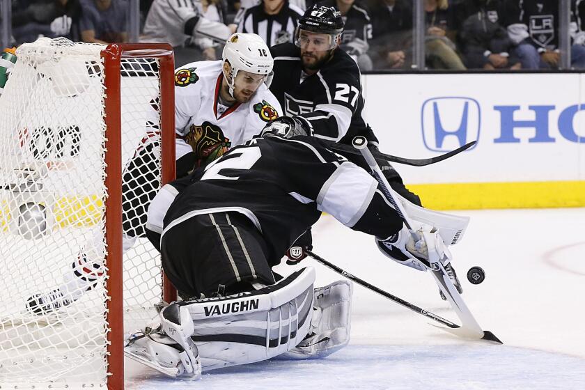 Kings goalie Jonathan Quick makes a save on a shot by Chicago Blackhawks forward Marcus Kruger, left, in front of defenseman Alec Martinez during the second period of the Kings' 4-3 win in Game 3 of the Western Conference finals at Staples Center.