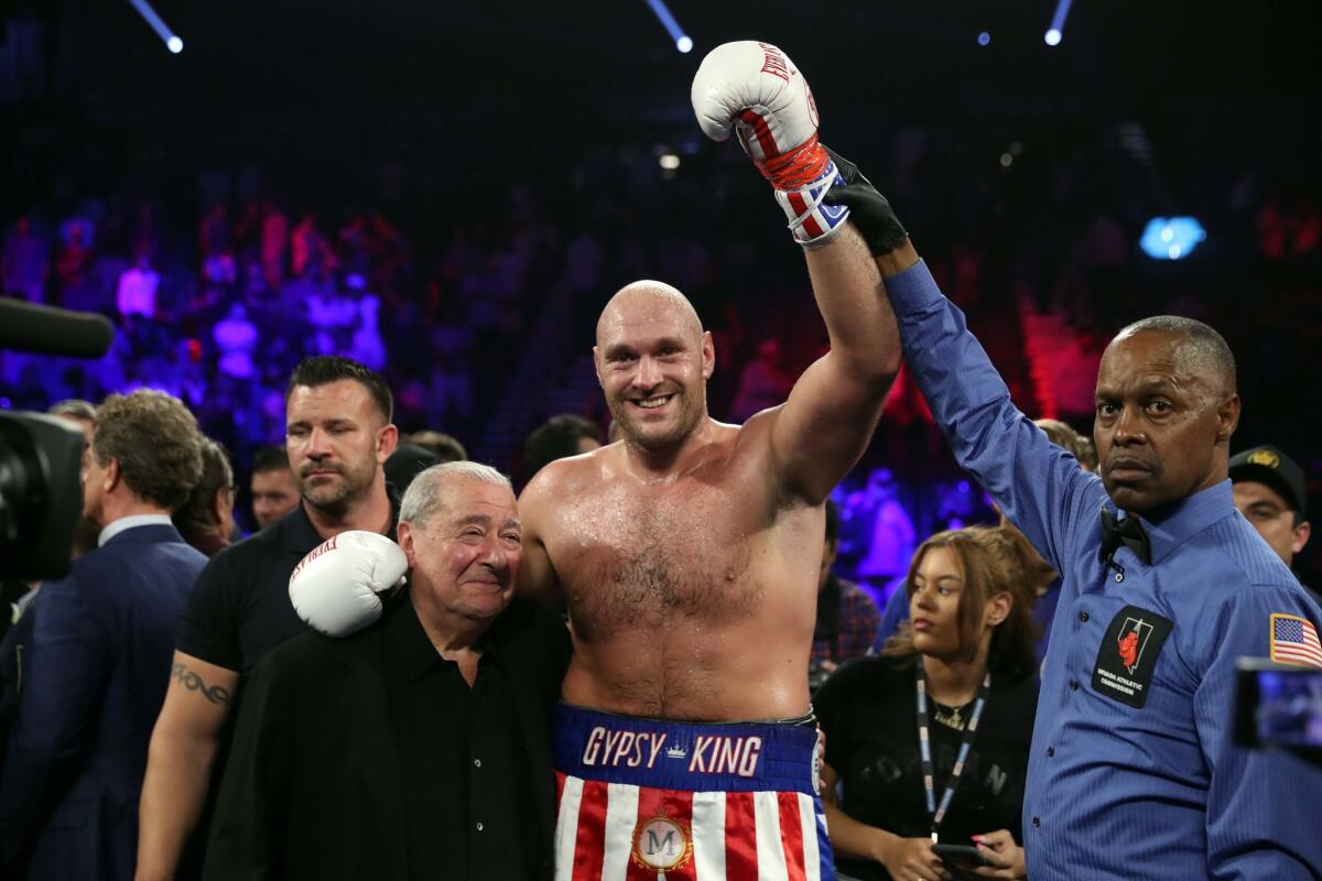 Tyson Fury celebrates with boxing promoter Bob Arum, left. Fury defeated Tom Schwarz in a heavyweight boxing match in Las Vegas on Saturday.