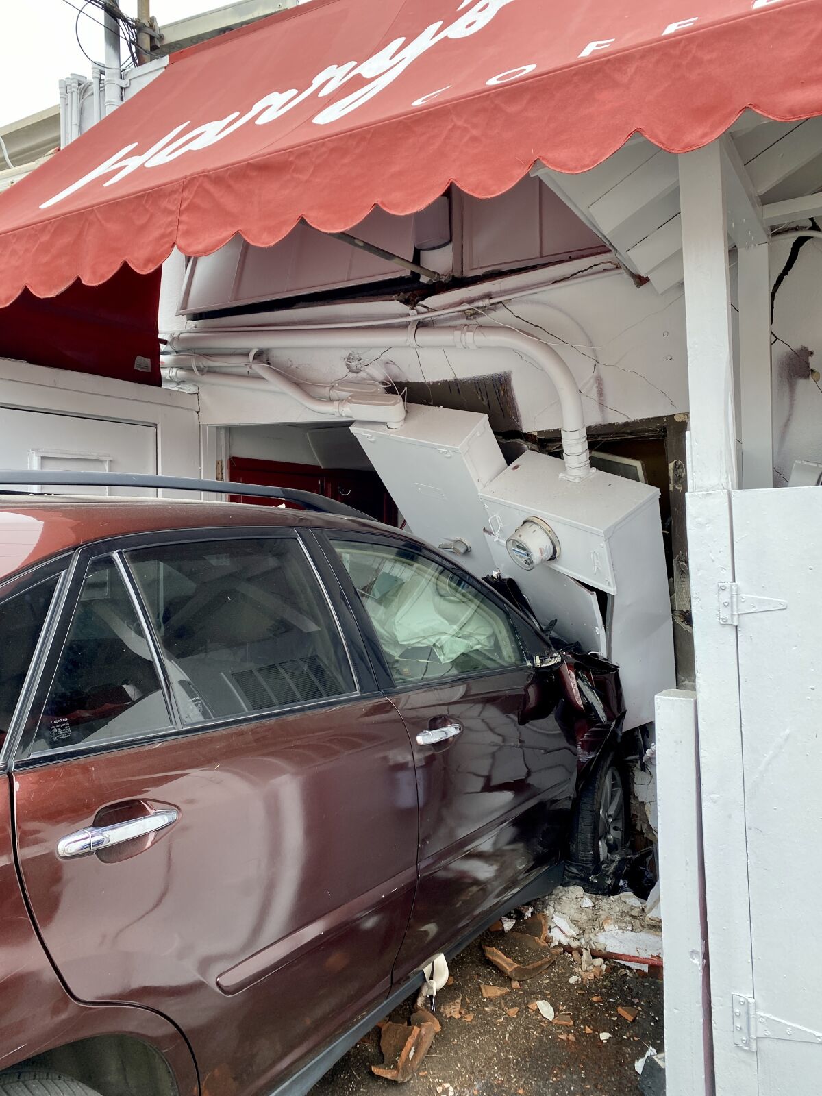 A car crashed into the rear of Harry's Coffee Shop on May 12, injuring three people.