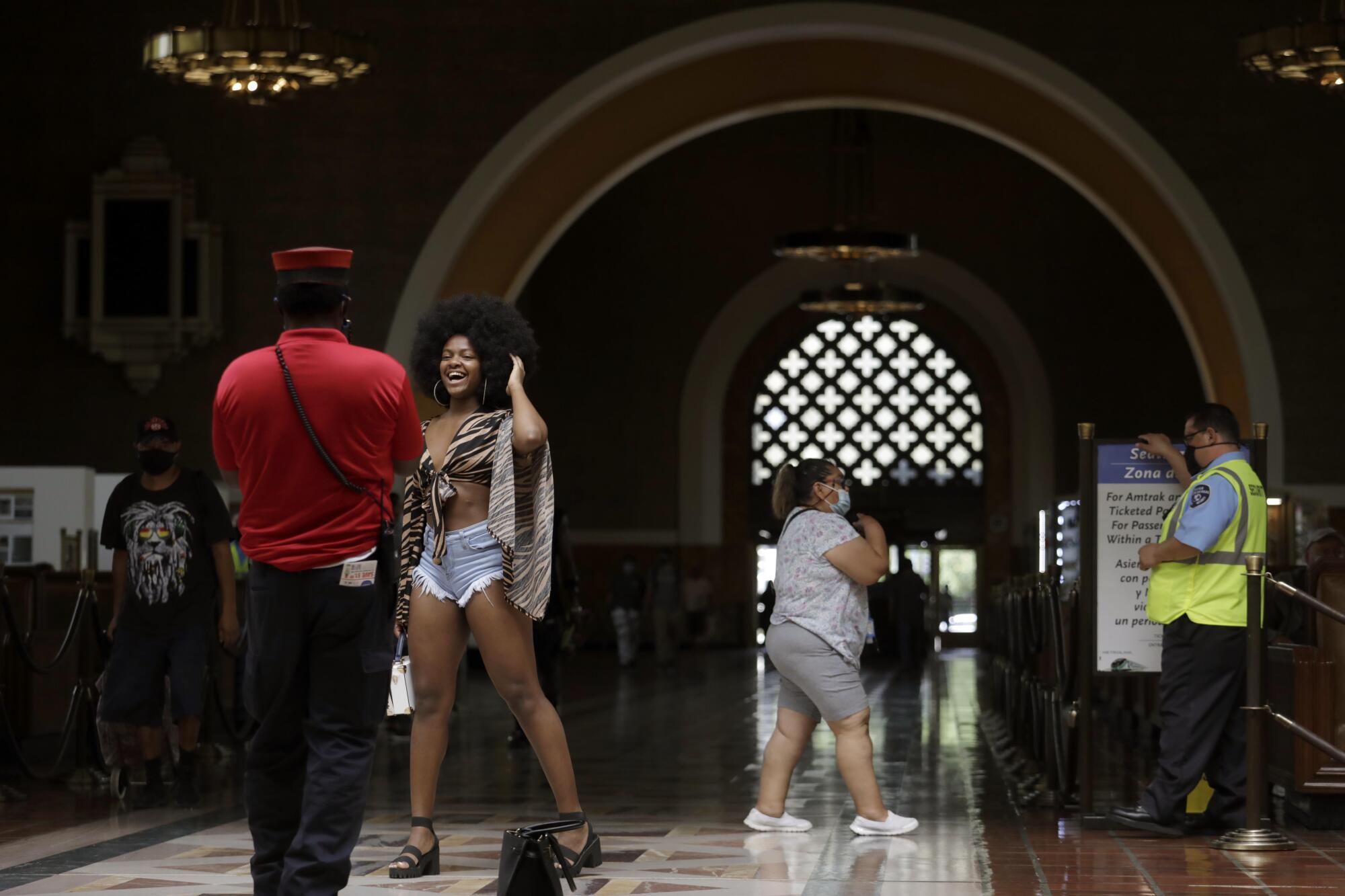 A woman has her picture taken in a train station 