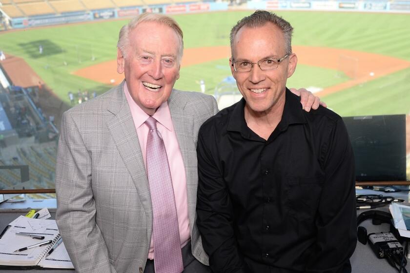 Legendary Dodgers broadcaster Vin Scully stands alongside Dodgers historian Mark Langill at Dodger Stadium.