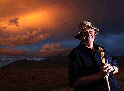 The intrepid Tony Hillerman, with walking stick in hand. The stick, carved from the rib of a saguaro cactus, bears the image of another roamer  Kokopelli.