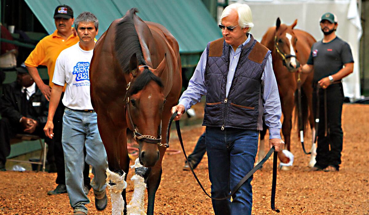 Hall of Fame trainer Bob Baffert, right, leads Preakness Stakes winner American Pharoah out of the stakes barn on Sunday at Pimlico Race Course in Baltimore. Amrican Pharoah won the 140th Preakness Stakes by 7 lengths.