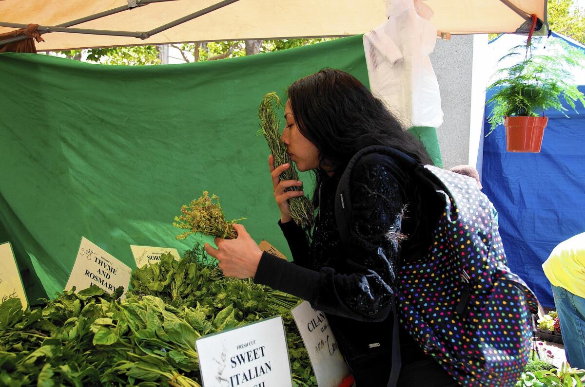 Mercy Mena, 25, uses her Supplemental Nutrition Assistance Program benefits at Heart of the City Farmers Market in San Francisco. Other California farmers markets have also begun to reach more consumers who receive nutritional benefits.