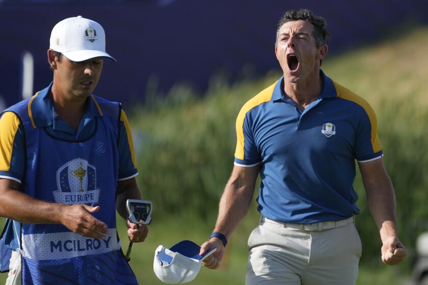 Europe's Rory McIlroy celebrates after winning his singles match against United States' Sam Burns.