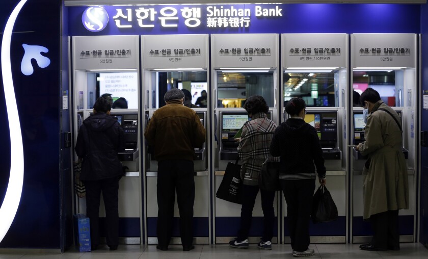 South Korean consumers at a ATM machine in Seoul, South Korea in 2013.