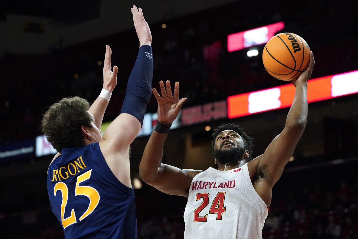 Maryland forward Donta Scott (24) goes up for a shot against Quinnipiac forward Jacob Rigoni (25) during the first half of an NCAA college basketball game, Tuesday, Nov. 9, 2021, in College Park, Md. (AP Photo/Julio Cortez)
