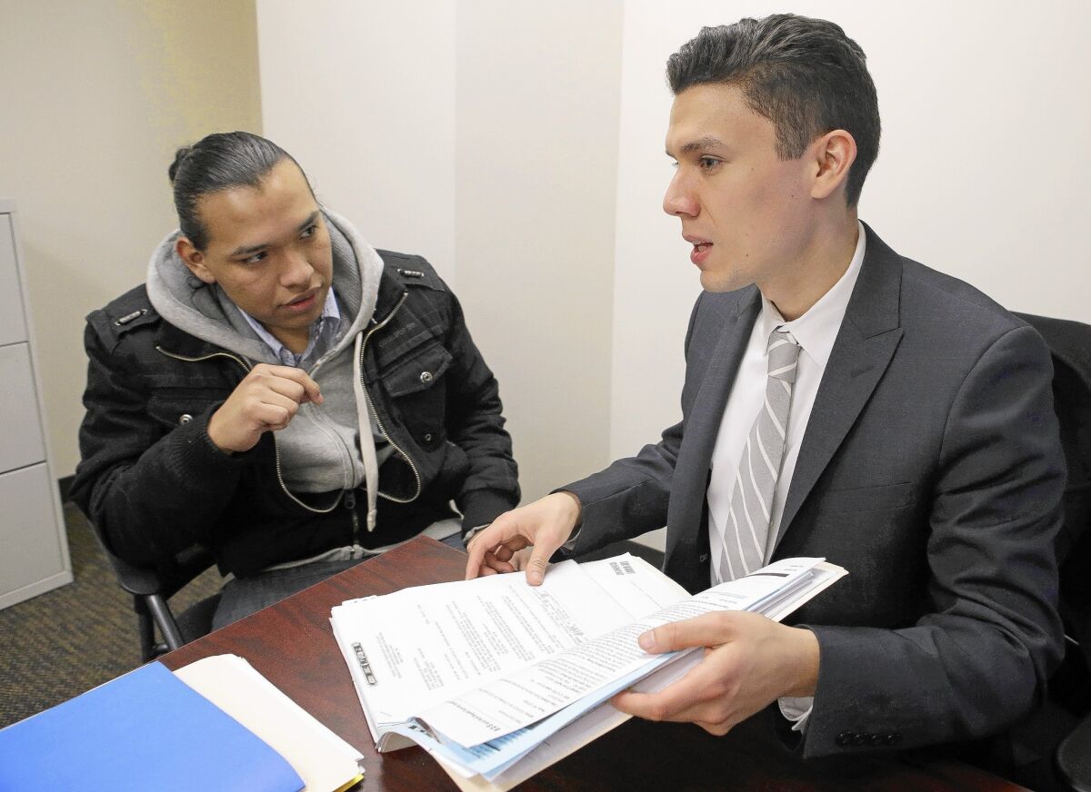 Oscar Hernandez, left, meets with attorney Ruben Loyo at Brooklyn Defender Services in New York. Hernandez, 20, is being helped by a pilot program in the city that provides free legal aid for low-income immigrants who face deportation.