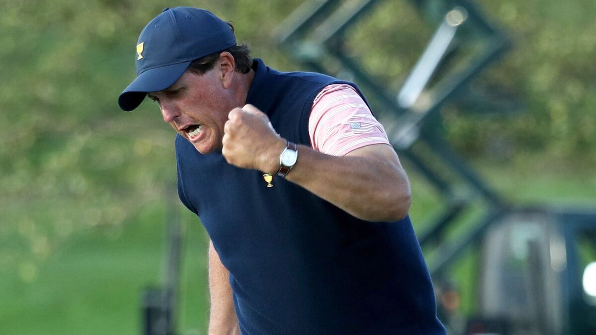 Phil Mickelson reacts after sinking his birdie putt at No. 18 to clinch a win with teammate Kevin Kisner on Friday at the Presidents Cup.