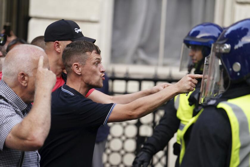 Protesters confront police officers during the "Enough is Enough" protest in Whitehall, London, Wednesday July 31, 2024, following the fatal stabbing of three children at a Taylor Swift-themed summer holiday dance and yoga class on Monday in Southport. (Jordan Pettitt/PA via AP)