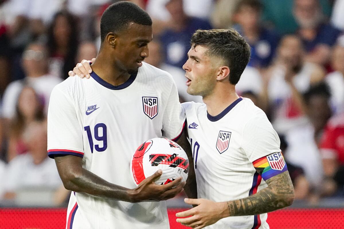 U.S. forward Christian Pulisic hands the ball to Haji Wright prior to a penalty kick.