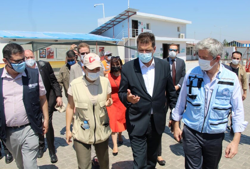 Janez Lenarcic, EU commissioner for Crisis Management, second right, speaks with aid workers at the Bab- al-Hawa border crossing between Turkey and northern Syria, Thursday, July 8, 2021. A top EU official said Thursday that the closure of the only remaining border crossing that allows aid into areas held by Syrian insurgents would have "catastrophic" consequences for millions of Syrians depending on assistance. Lenarcic, EU commissioner for Crisis Management, urged the U.N. Security Council to vote to keep the Bab- al-Hawa border crossing operational and for other border crossings to be reopened. (IHA via AP)
