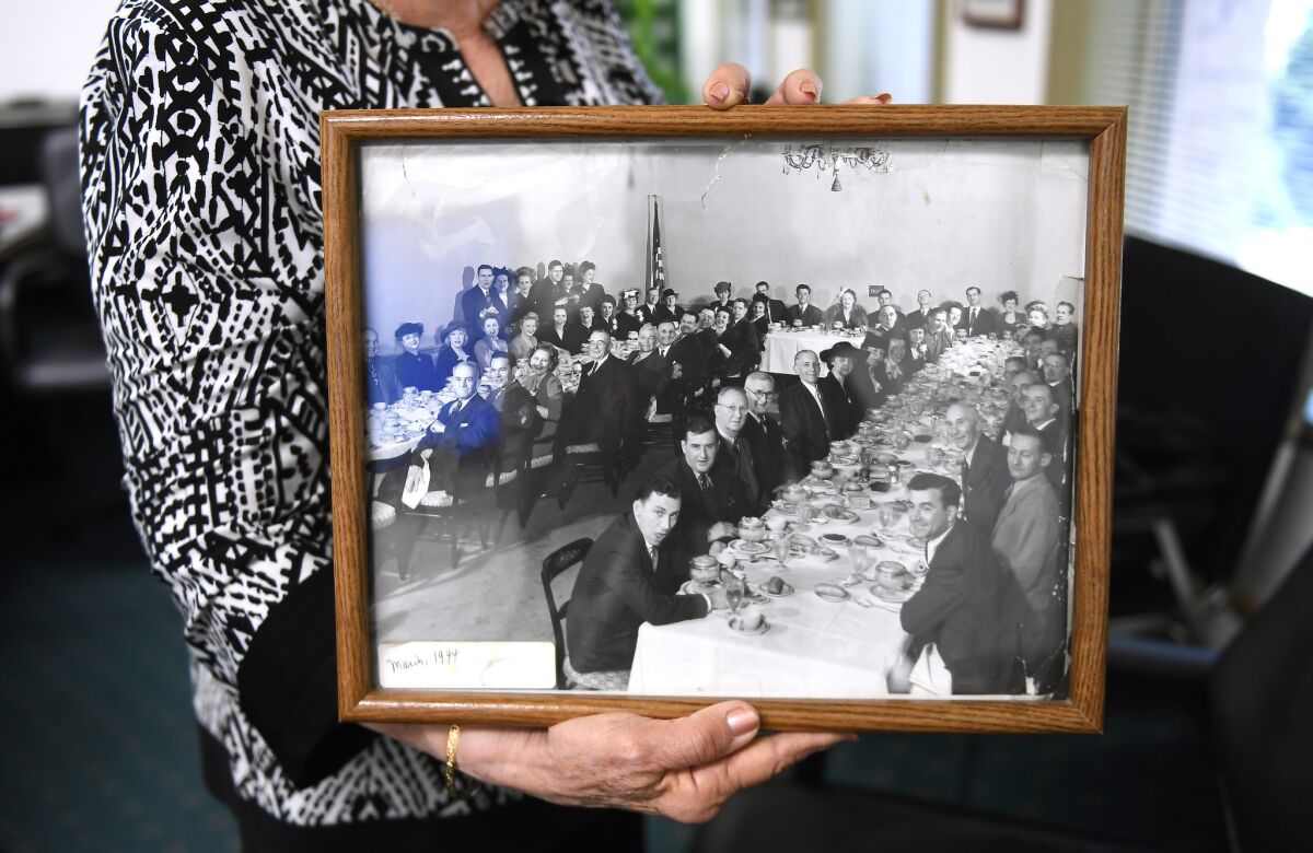 Raquel Bensimon, who led Dearden's for nearly two decades, holds a photograph of employees taken in March 1944.