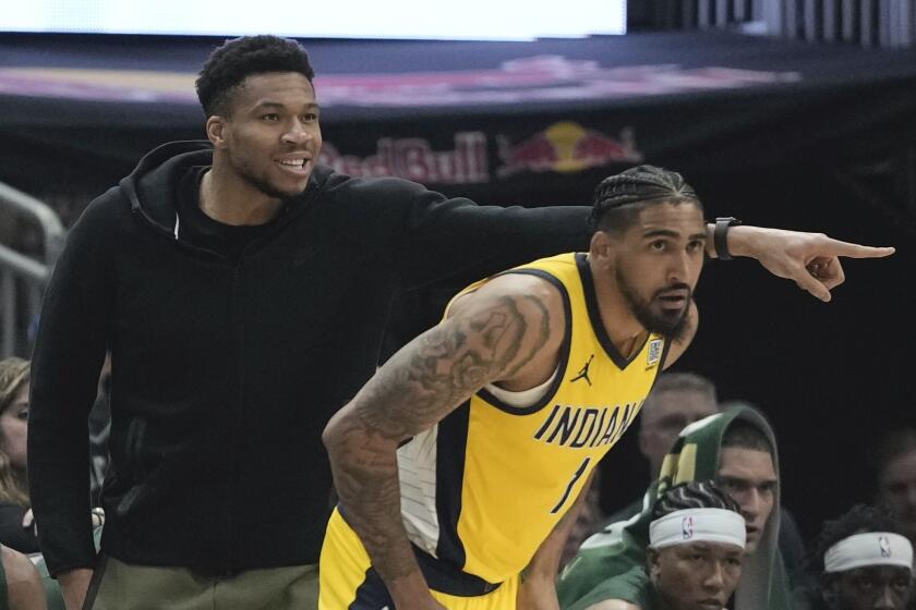 Milwaukee Bucks' Giannis Antetokounmpo reacts from the bench in front of Indiana Pacers' Obi Toppin during the first half of Game 1 of the NBA playoff basketball game Sunday, April 21, 2024, in Milwaukee. (AP Photo/Morry Gash)