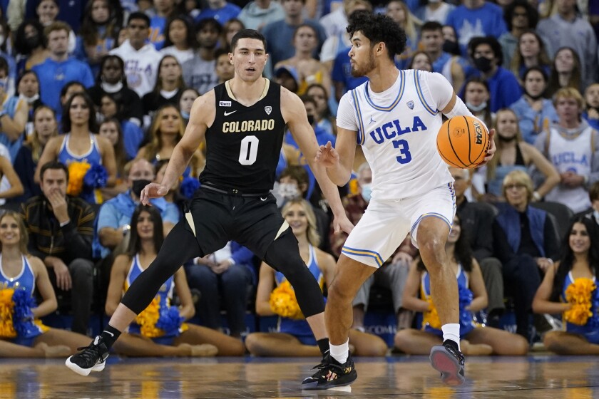 Colorado guard Luke O'Brien (0) defends against UCLA guard Johnny Juzang (3) during the first half of an NCAA college basketball game in Los Angeles, Wednesday, Dec. 1, 2021. (AP Photo/Ashley Landis)