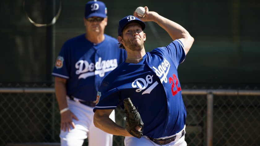 Dodgers ace Clayton Kershaw warms up under the watch of pitching coach Rick Honeycutt before throwing live batting practice Saturday at Camelback Ranch.