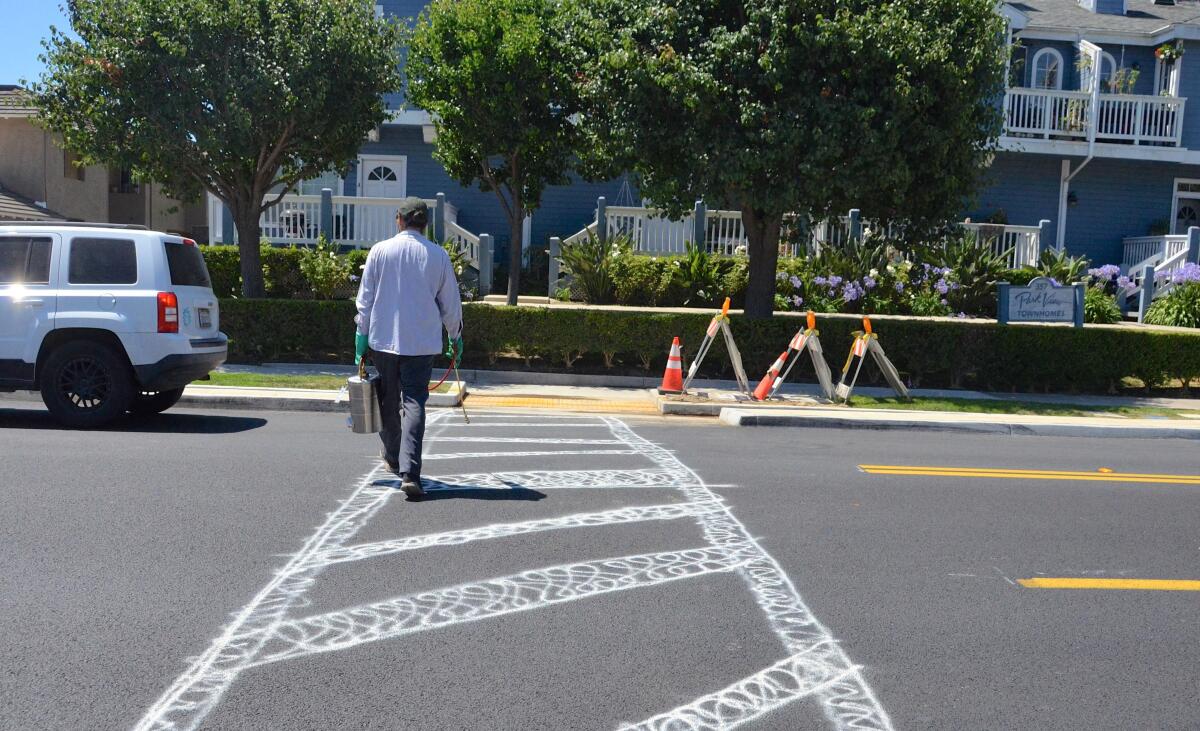 A man bravely crosses Costa Mesa's Wilson Street via a "citizen-installed" crosswalk on his way to work Thursday.