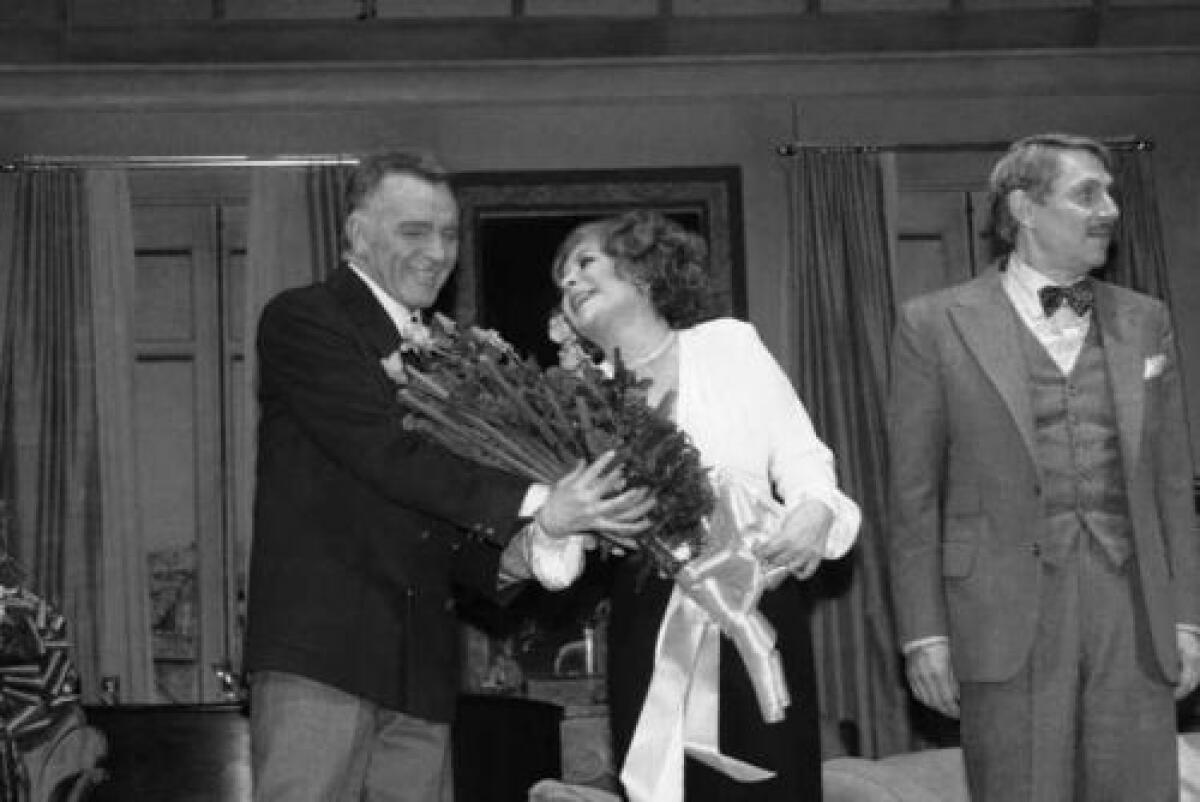 Elizabeth Taylor receives roses from Richard Burton during the curtain call at the Broadway opening of Noel Coward's "Private Lives" in 1983.