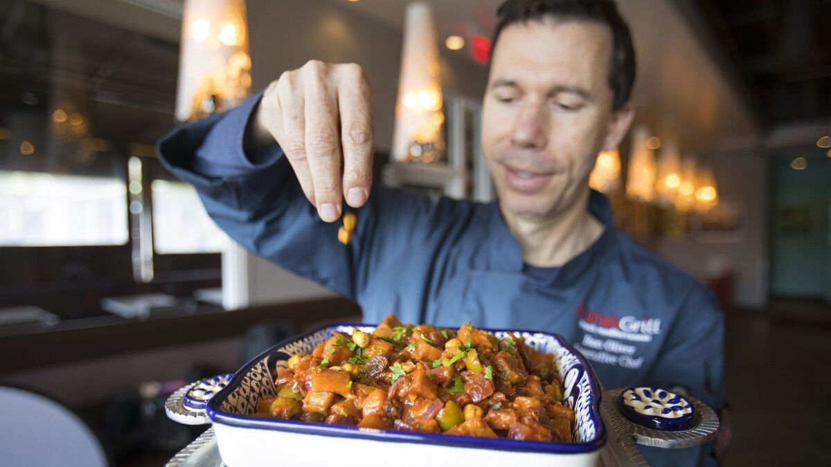Ron Oliver, executive chef at Luna Grill, finishes preparing Eggplant Tagine.