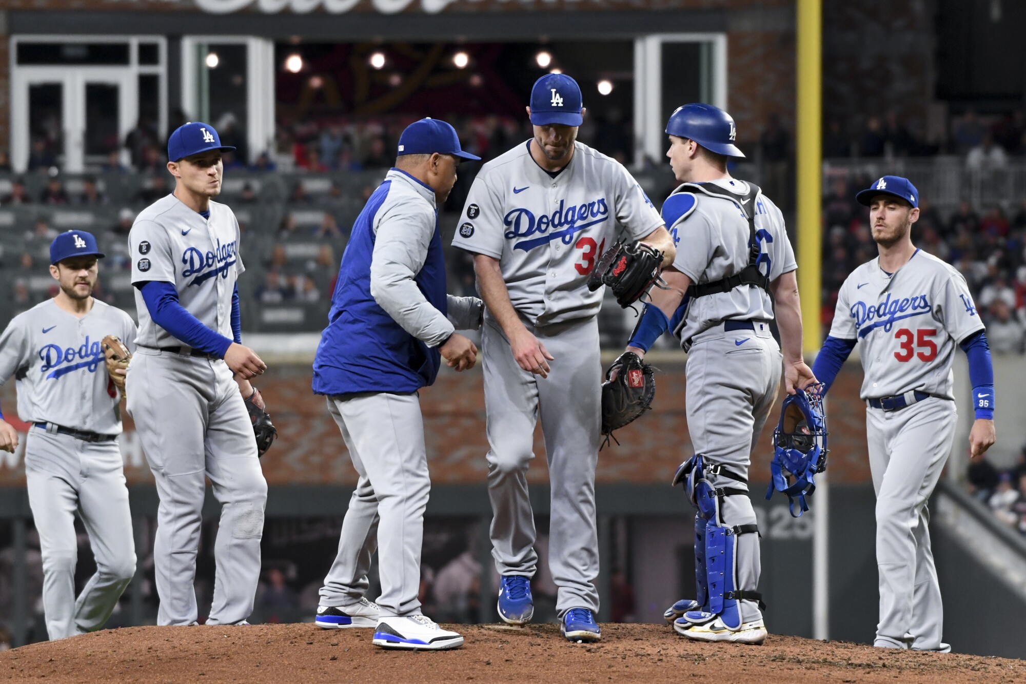 Dodgers manager Dave Roberts, left, relieves starting pitcher Max Scherzer during the fifth inning of Game 2 of the NLCS.