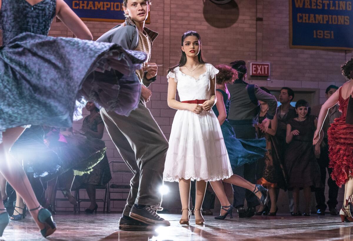 Rachel Zegler, wearing a white dress and surrounded by dancers, in “West Side Story” (2021)