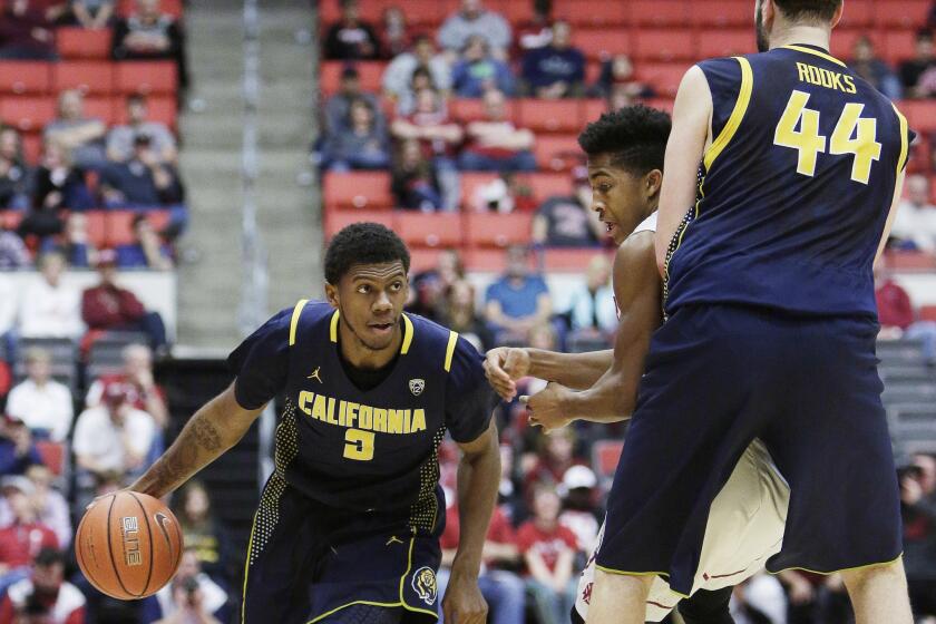 California guard Tyrone Wallace (3) drives around Washington State's Ny Redding, center, as teammate Kameron Rooks (44) provides a screen during the second half.
