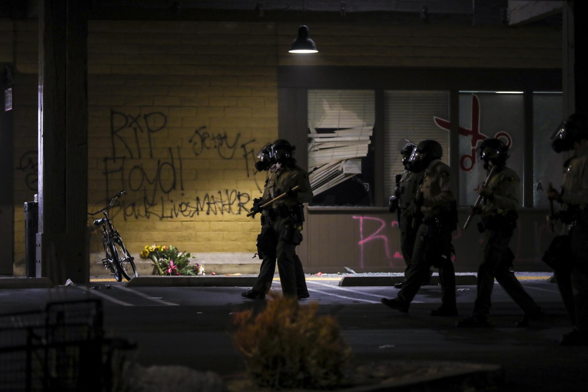 Deputies and La Mesa police move in to clear out protestors from the La Mesa Springs Shopping Center where looters had set the grocery store Vons and a small sporting good store on fire.