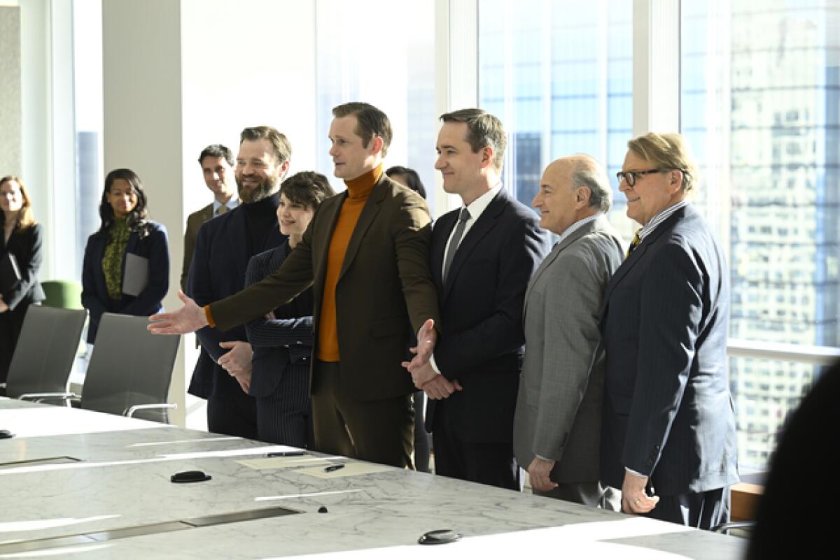 A group of people posing for a photo in a boardroom