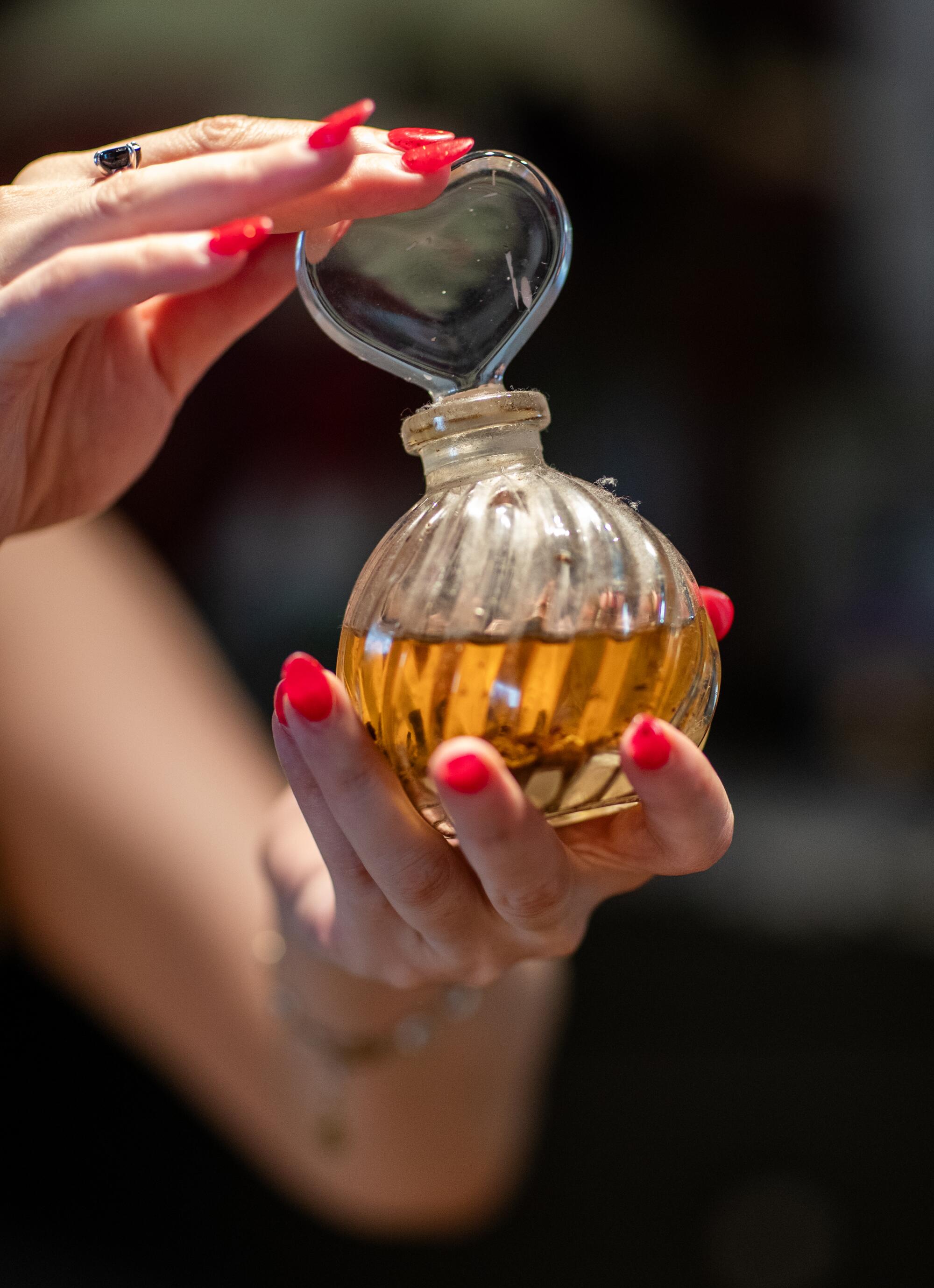 Hands hold a vial of orange oil.