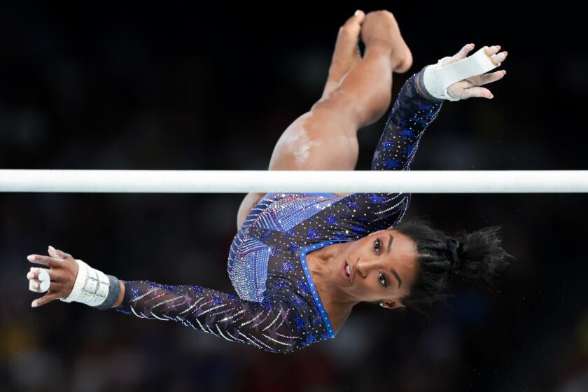 Simone Biles competes on the uneven bars during the women's all around gymnastic final at the 2024 Paris summer Olympics
