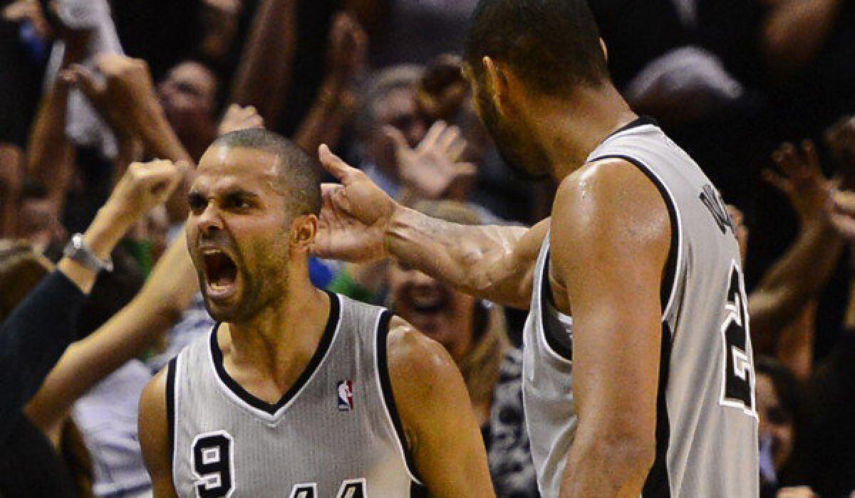 The Spurs' Tony Parker, left, celebrates with teammate Tim Duncan after hitting a basket to win the game in the last second against the Thunder earlier this season.