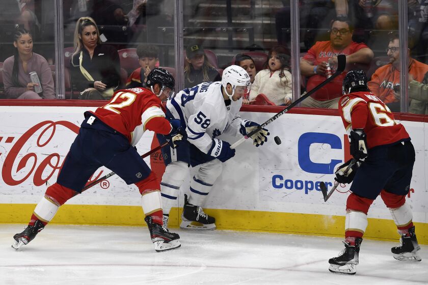 Toronto Maple Leafs left wing Michael Bunting (58) tries to control the puck in front of Florida Panthers center Eric Staal (12) during the second period of an NHL hockey game, Thursday, March 23, 2023, in Sunrise, Fla. (AP Photo/Michael Laughlin)