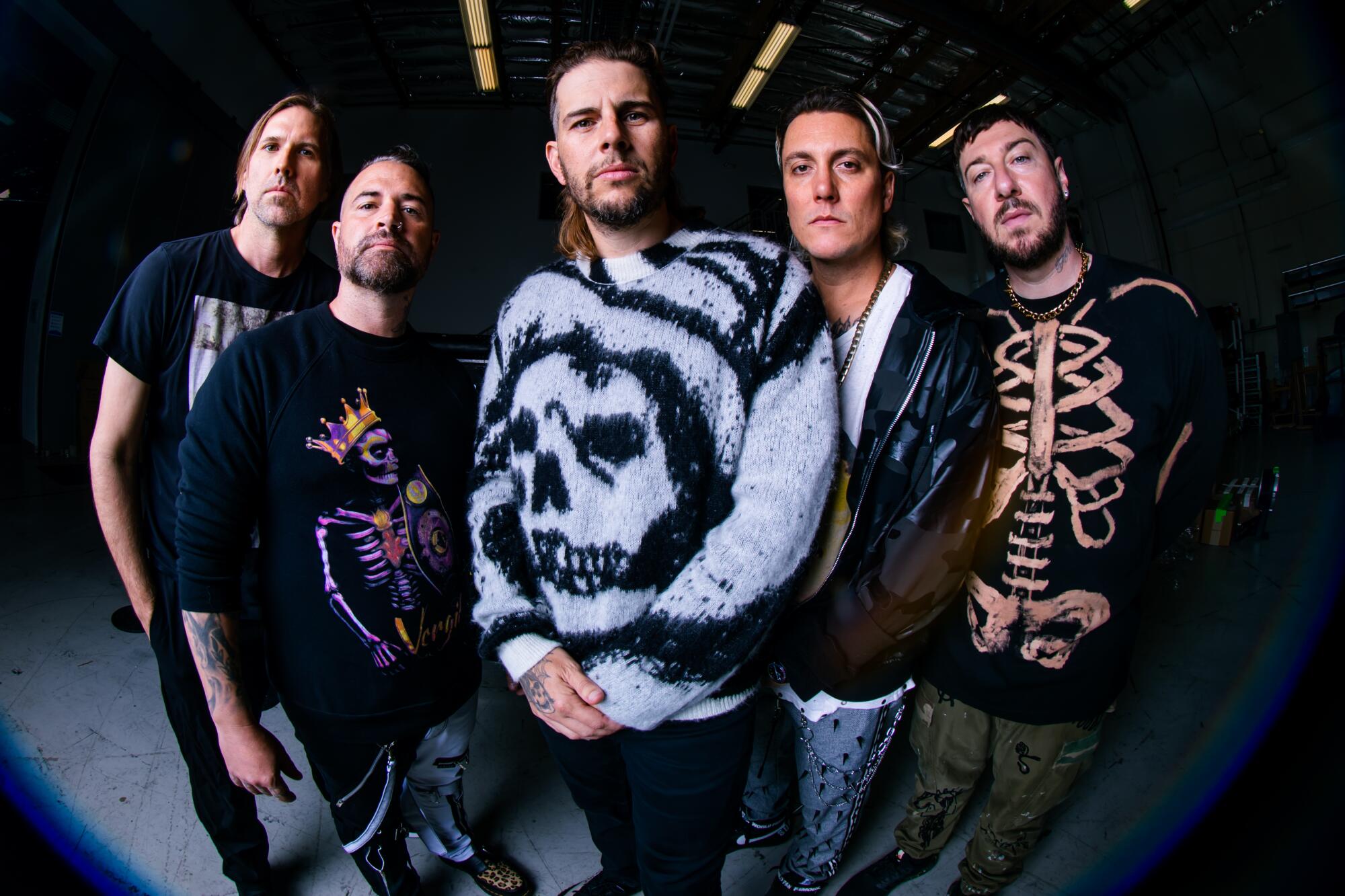 The five members of Avenged Sevenfold stare into the camera.
