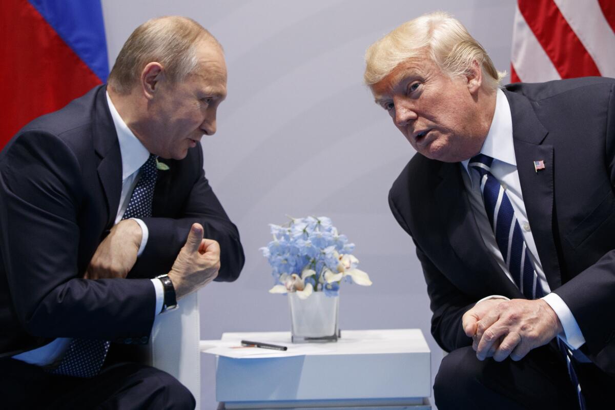 Russian President Vladimir Putin and then-President Trump lean together to talk