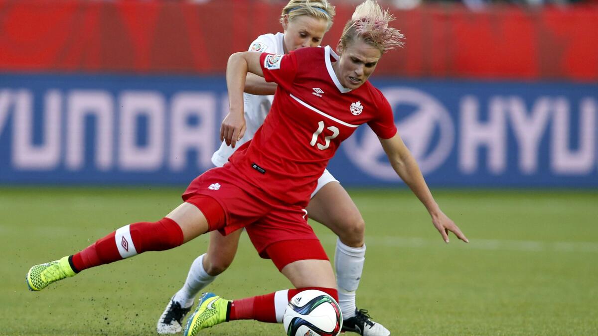 Canada's Sophie Schmidt (13) and New Zealand's Betsy Hassett battle for the ball during the second half of their Women's World Cup group game on Thursday.
