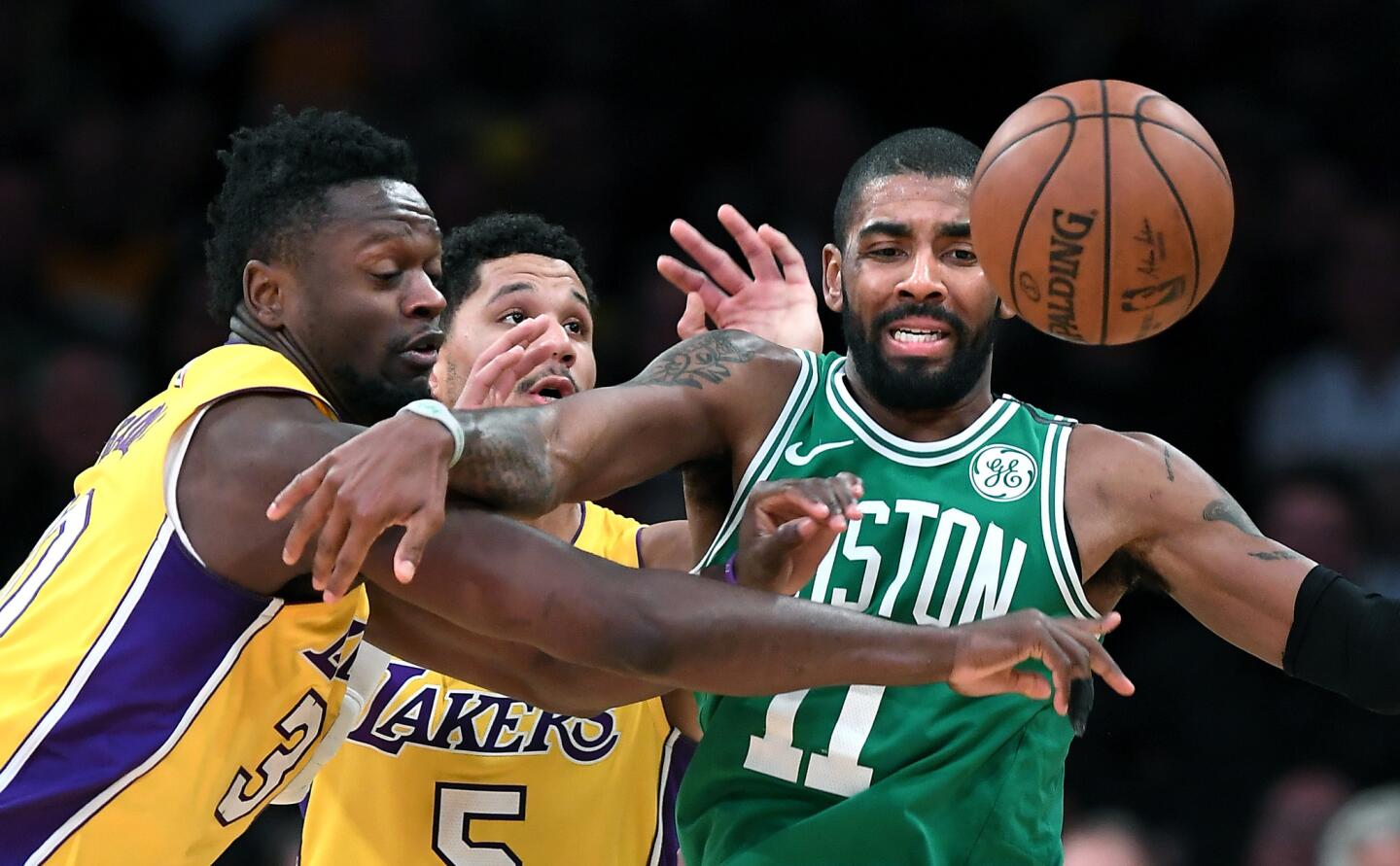 Lakers forward Julius Randle knocks the ball away form Celtics guard Kyrie Irving during the fourth quarter of a game Tuesday at Staples Center.