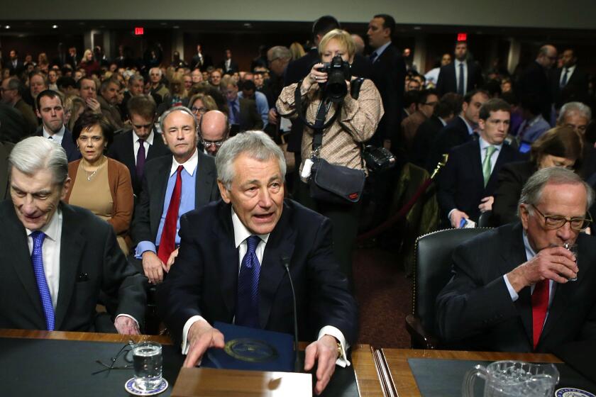Former Sen. Chuck Hagel (R-Neb.), center, takes a seat at his confirmation hearing to become the next secretary of defense on Capitol Hill. During the nearly eight hours of Hagel¿s hearing, no more than 10 minutes were spent on Afghanistan.