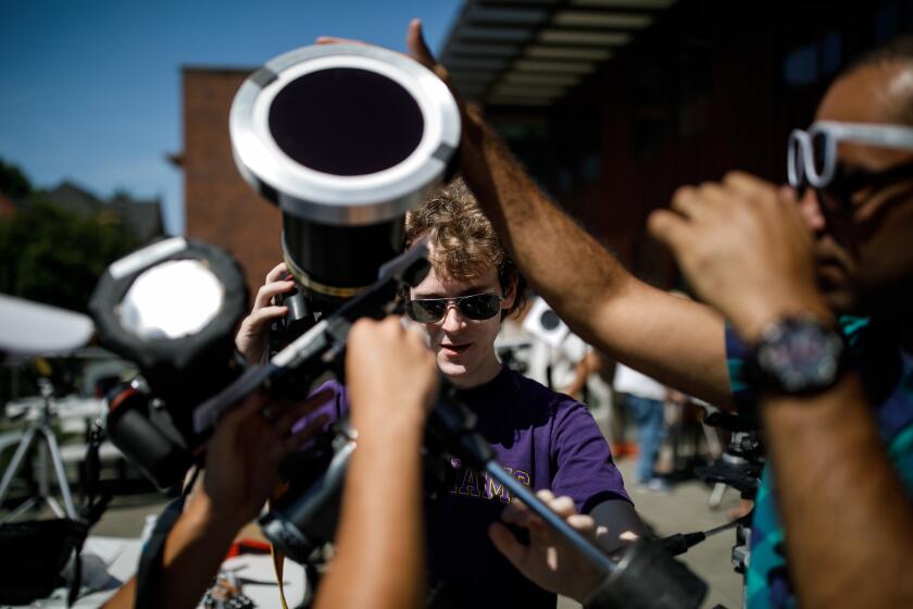 Allen B. Davis and other students help setup a telescope to observe the upcoming solar eclipse in Willamette University in Salem, Ore.