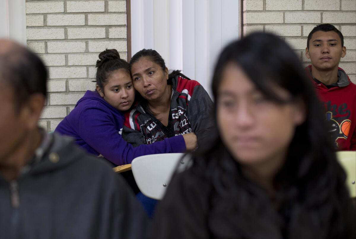 En esta imagen del 5 de enero de 2016, migrantes centroamericanas se abrazan mientras esperan a recibir asistencia en un centro para familias recién llegadas con niños, en la iglesia católica del Sagrado Corazón en McAllen, Texas.