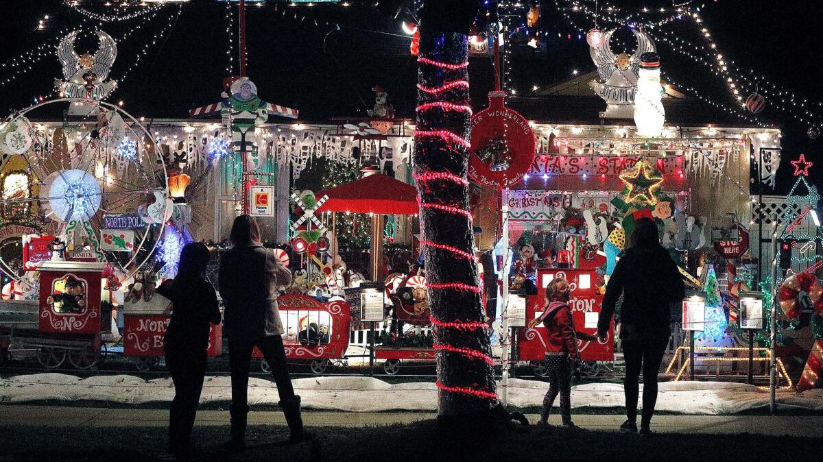 People get a look at the home of the Norton Family's Winter Wonderland in Burbank on Tuesday. A steady stream of people either walked up to the decorated home on the sidewalk or drove by slowly.